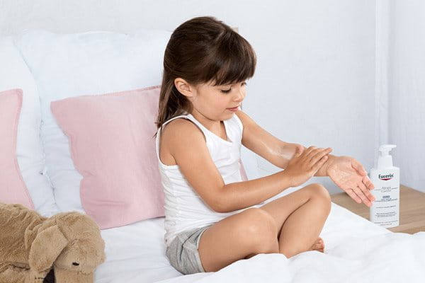 Child applying Eucerin OMEGA Balm